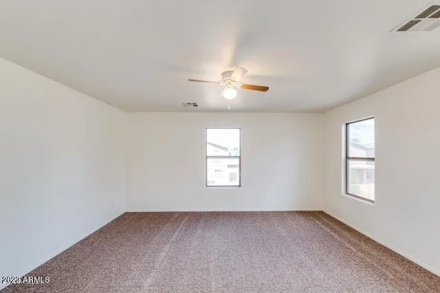 an empty room with closet and windows