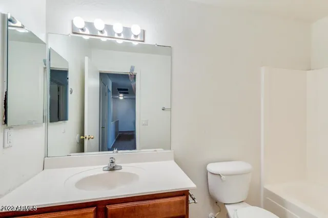 a bathroom with a sink mirror vanity and toilet