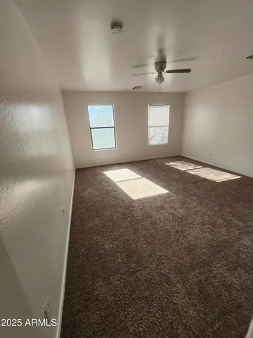 an empty room with a chandelier fan