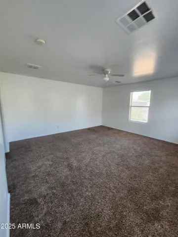 en empty room with windows and ceiling fan