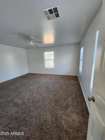 a view of an empty room with a chandelier fan