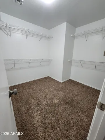 an empty room with a fan & a window