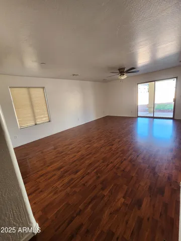 an empty room with windows and fan