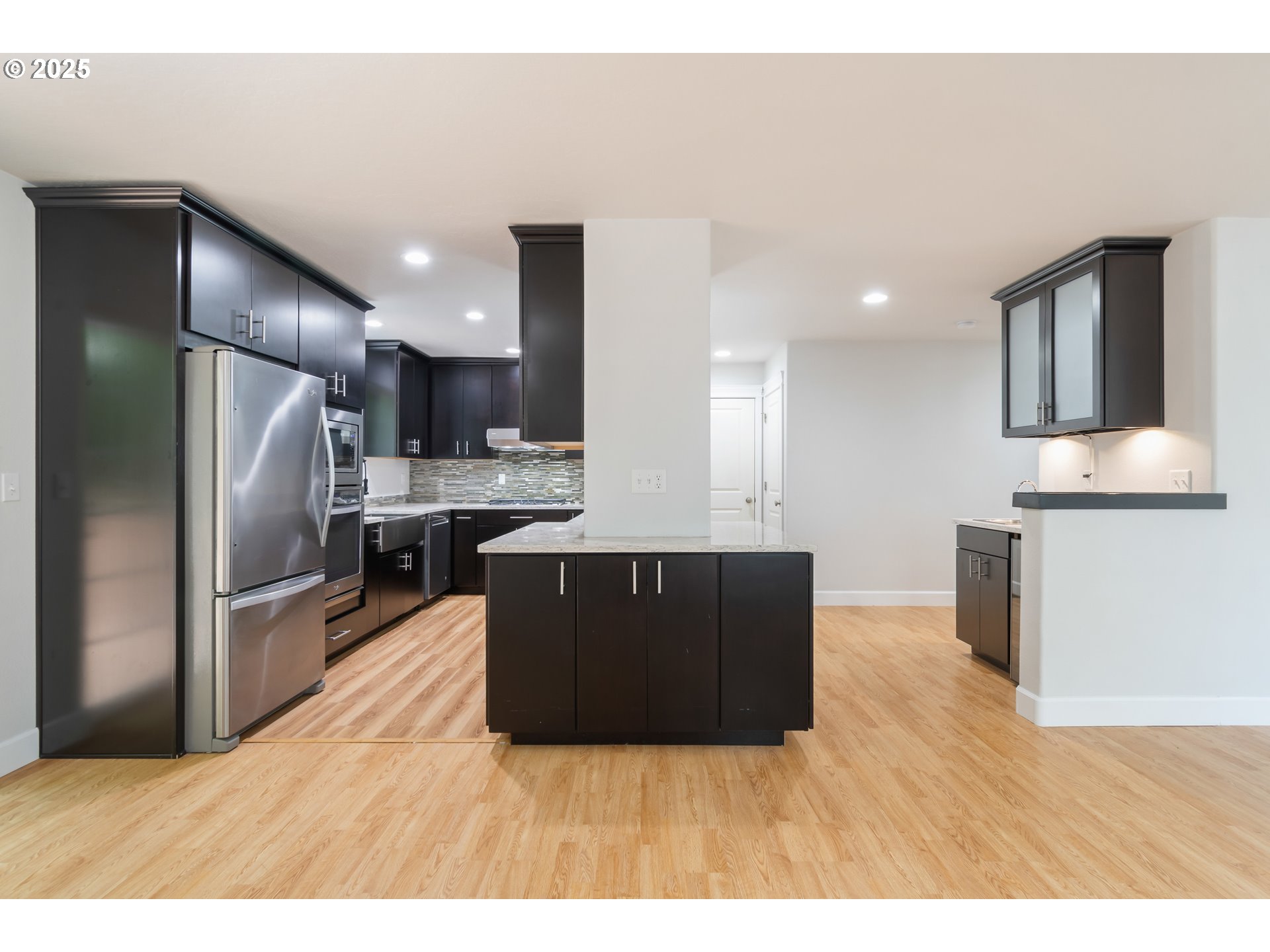2795 Mallory Lane Eugene, OR 97401 - Photo 9 of 44 a kitchen with stainless steel appliances kitchen island granite countertop a refrigerator a stove and a wooden floors