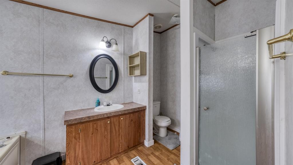 1700 Bennett Road Millsap, TX 76066 - Photo 19 of 40 a bathroom with a granite countertop toilet a sink and a mirror