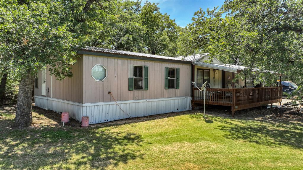 1700 Bennett Road Millsap, TX 76066 - Photo 2 of 40 a backyard of a house with wooden fence and a tree