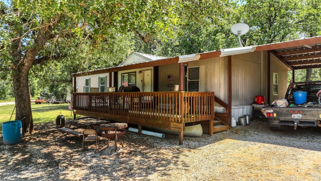 1700 Bennett Road Millsap, TX 76066 - Photo 3 of 40 a view of a house with a wooden deck and a yard
