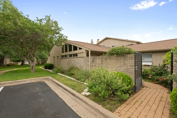 a front view of a house with a yard and potted plants