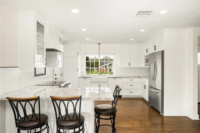 a kitchen with refrigerator cabinets dining table and chairs