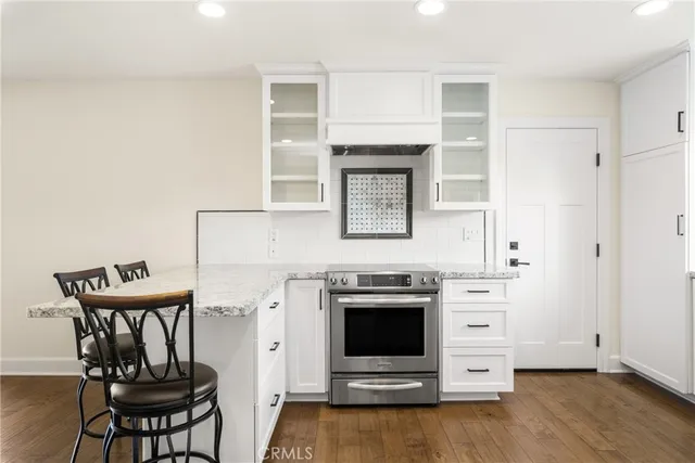 a kitchen with granite countertop a stove and a refrigerator