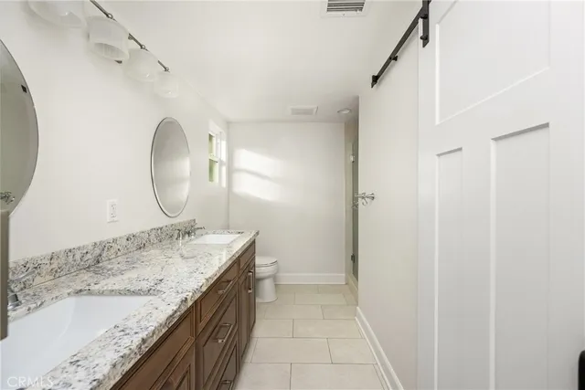 a bathroom with a granite countertop sink a mirror and shower