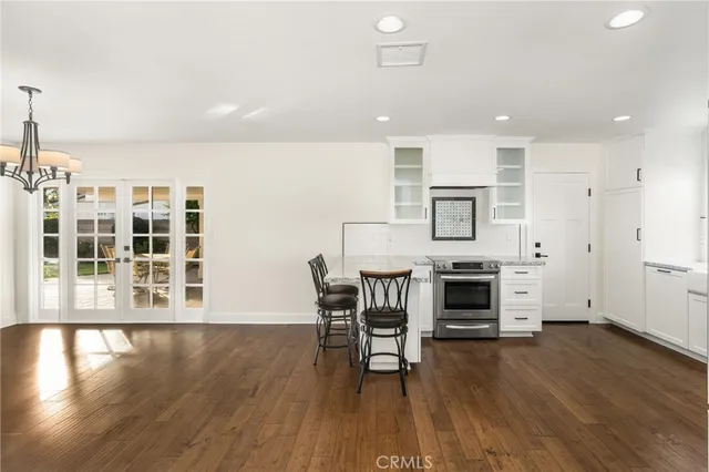 a kitchen with stainless steel appliances a dining table chairs stove and cabinets