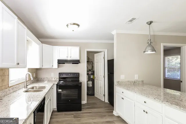 a kitchen with granite countertop a refrigerator stove and oven