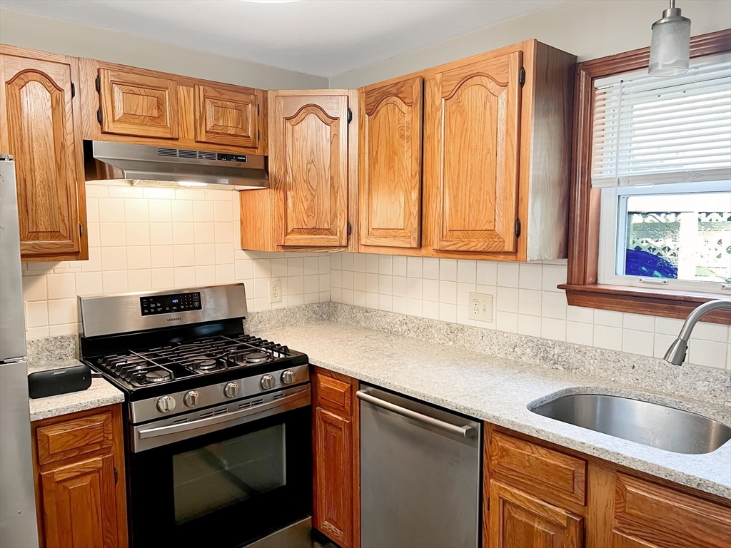 26 Wheeler Avenue, Unit 1 Rockland, MA 02370 - Photo 2 of 16 a kitchen with granite countertop a sink stainless steel appliances cabinets and a window