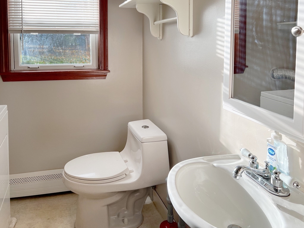 26 Wheeler Avenue, Unit 1 Rockland, MA 02370 - Photo 9 of 16 a white toilet sitting next to a bathroom sink