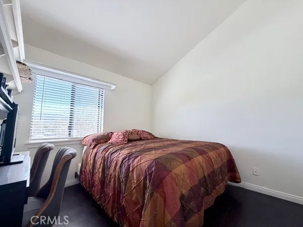 a bed sitting in a bedroom next to a window with wooden floor