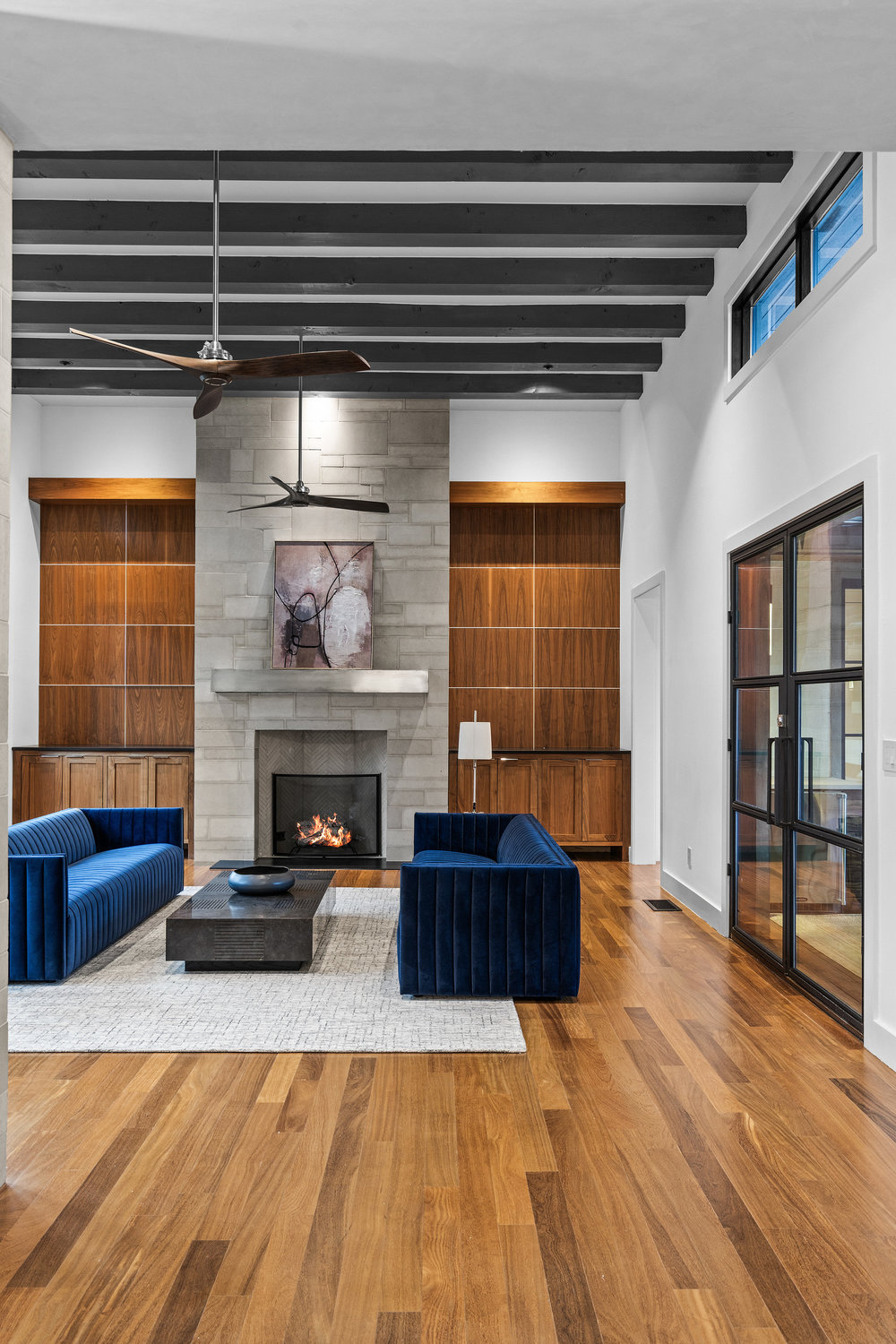 1905 Paisano Road Austin, TX 78746 - Photo 18 of 40 Dramatic exposed beams crown a fireside living space with rich wood built-ins and natural wood flooring.