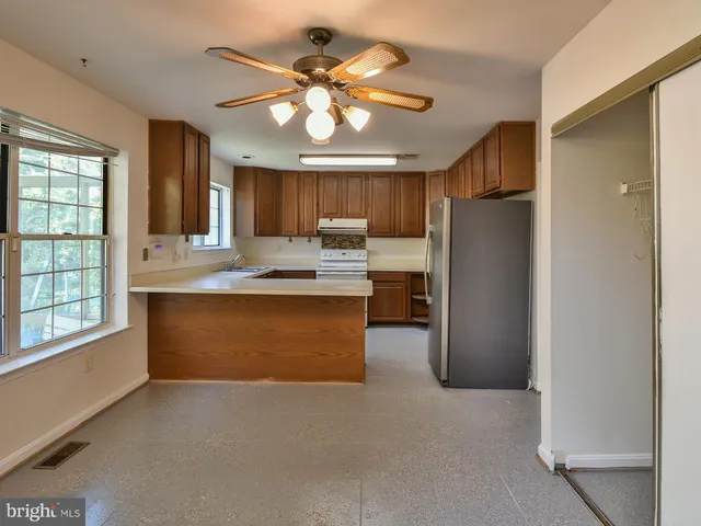 wooden floor in an empty room with a chandelier fan
