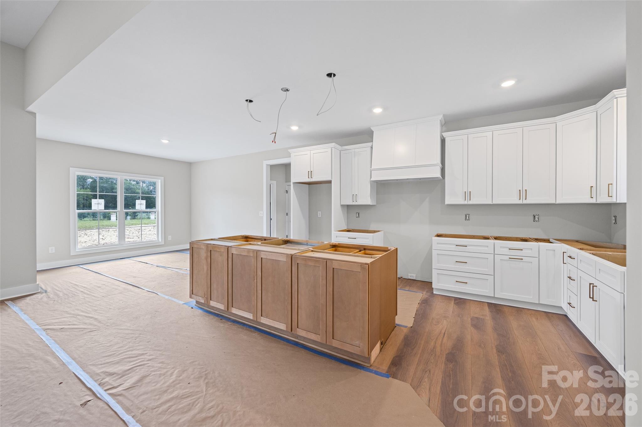 640 Edwards Road Fort Lawn, SC 29714 - Photo 6 of 39 a large kitchen with kitchen island a stove a sink a refrigerator and white cabinets with wooden floor