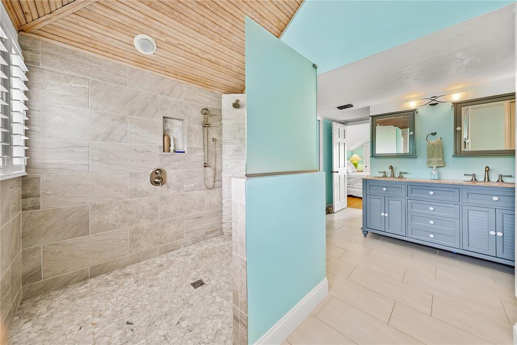12 Seawatch Drive Boca Grande, FL 33921 - Photo 35 of 54 a bathroom with a granite countertop sink a mirror and shower