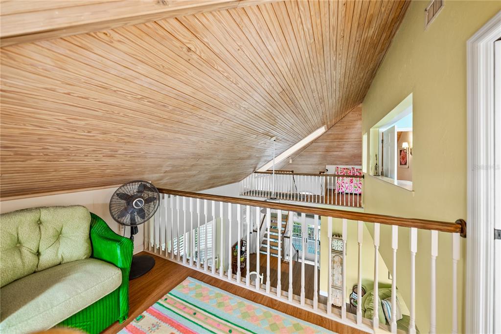 12 Seawatch Drive Boca Grande, FL 33921 - Photo 41 of 54 a balcony with wooden floor stairs and a bench