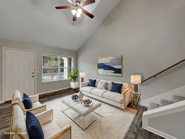 a living room with furniture ceiling fan and a window