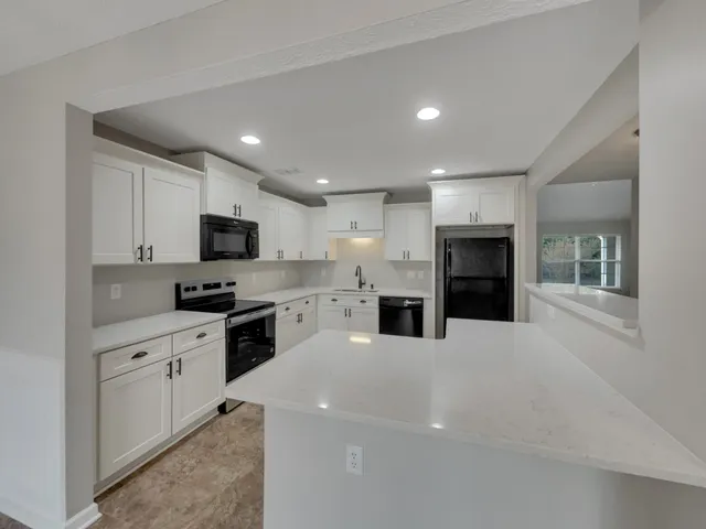 a large kitchen with granite countertop a stove top oven and sink
