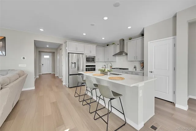 a kitchen with stainless steel appliances kitchen island a refrigerator and a stove top oven