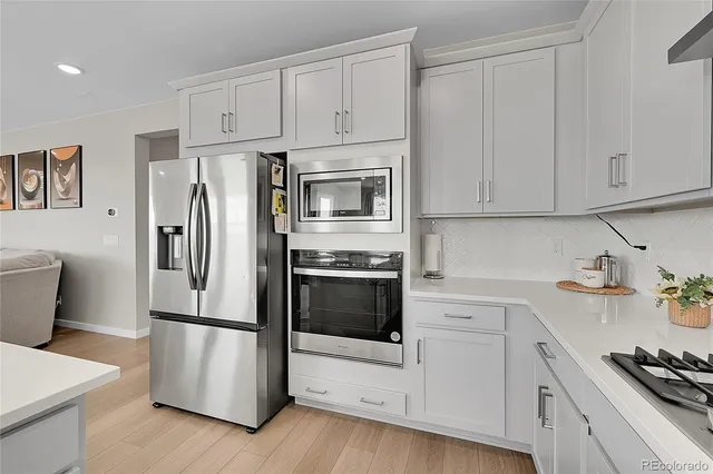 a kitchen with refrigerator a stove and cabinets