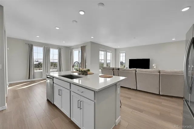 a kitchen with sink stove and refrigerator