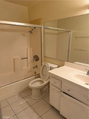 a bathroom with a granite countertop sink a toilet and a shower