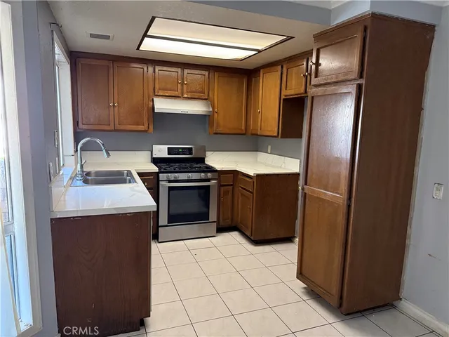 a kitchen with stainless steel appliances granite countertop a refrigerator a sink and a stove