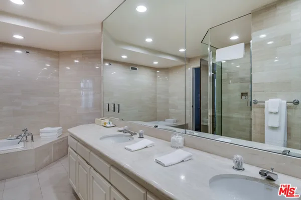 a bathroom with a granite countertop double vanity and a mirror