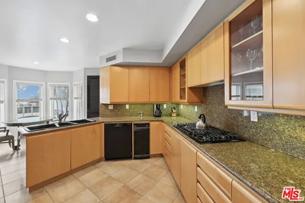 a kitchen with stainless steel appliances granite countertop a sink and cabinets