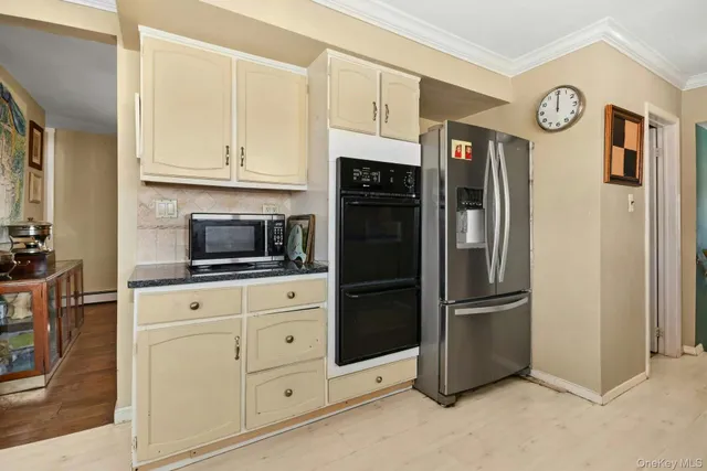 a kitchen with stainless steel appliances white cabinets and a refrigerator