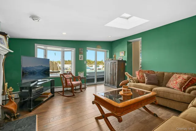 a living room with furniture a flat screen tv and a large window