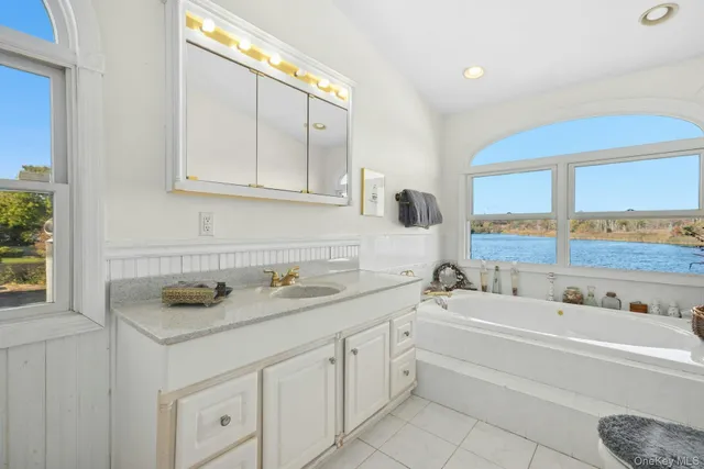 a bathroom with a tub sink and mirror