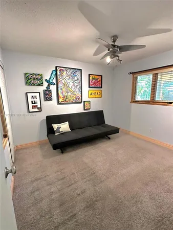 a living room with furniture and a ceiling fan