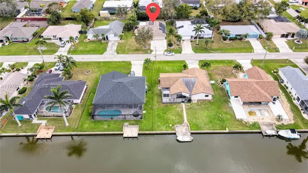 an aerial view of residential houses with outdoor space and parking
