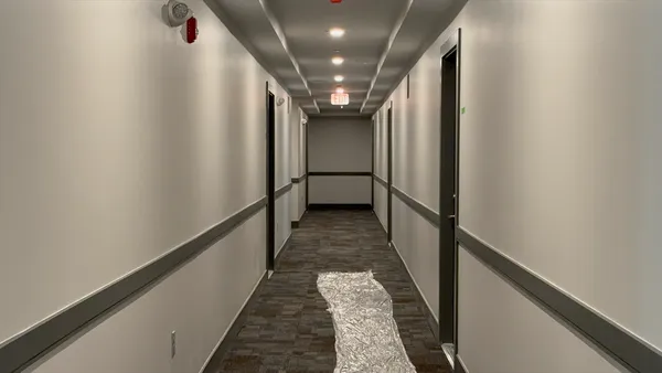 a view of a hallway with wooden floor and stairs