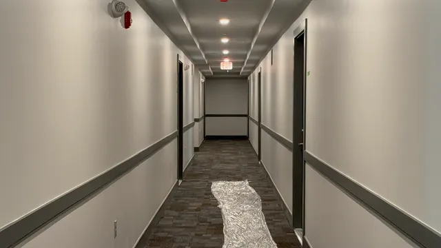 a view of a hallway with wooden floor and stairs