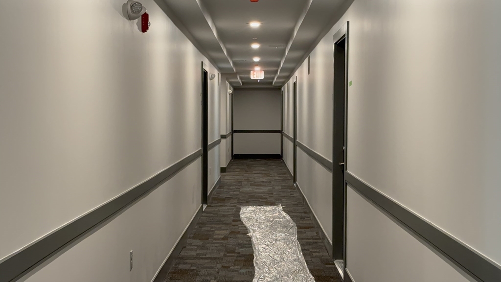 251 Sladen Street, Unit 103 Dracut, MA 01826 - Photo 17 of 27 a view of a hallway with wooden floor and stairs