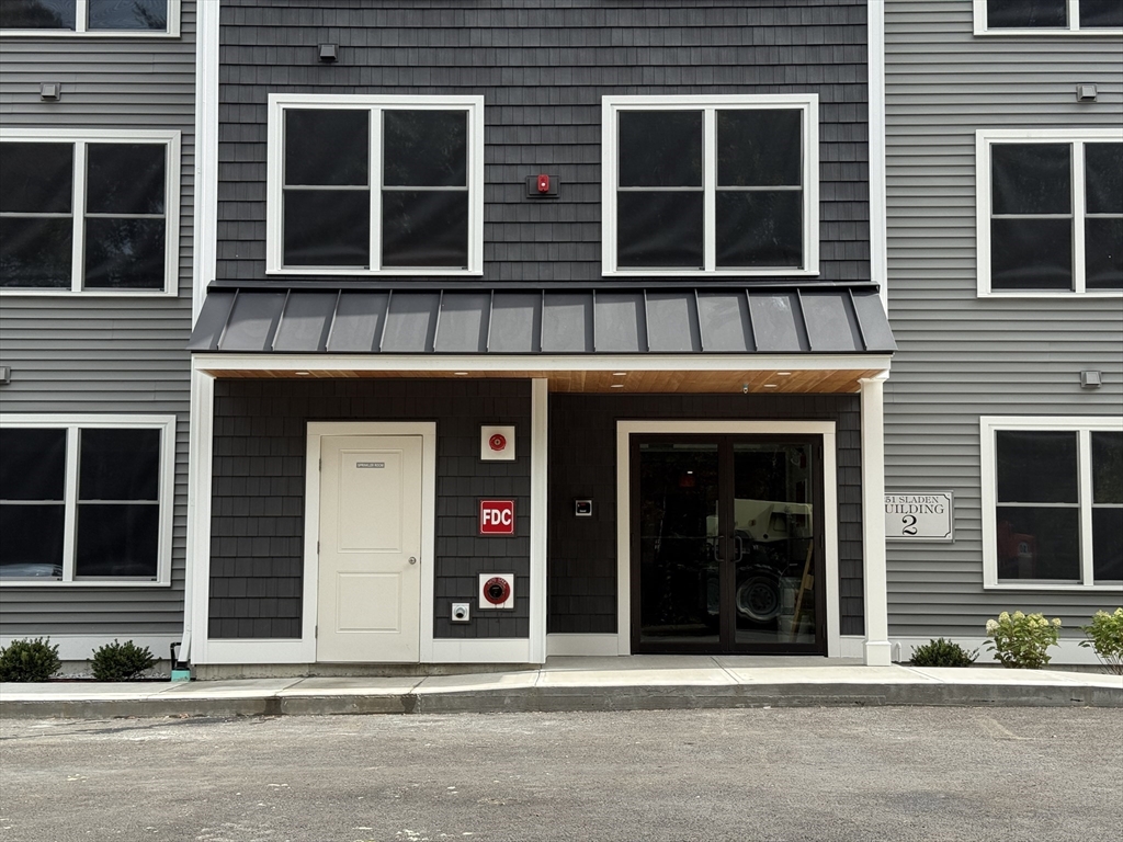 251 Sladen Street, Unit 103 Dracut, MA 01826 - Photo 25 of 27 a view of a building with a outdoor space