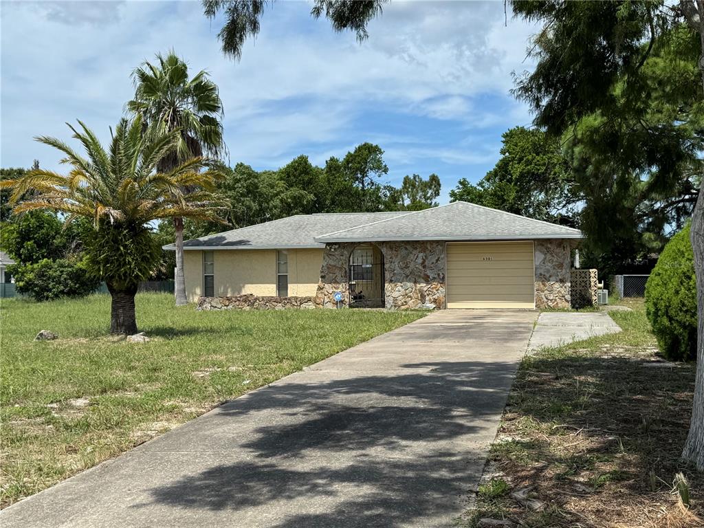 6501 Ridge Crest Drive Port Richey, FL 34668 - Photo 1 of 1 a front view of a house with a yard and garage