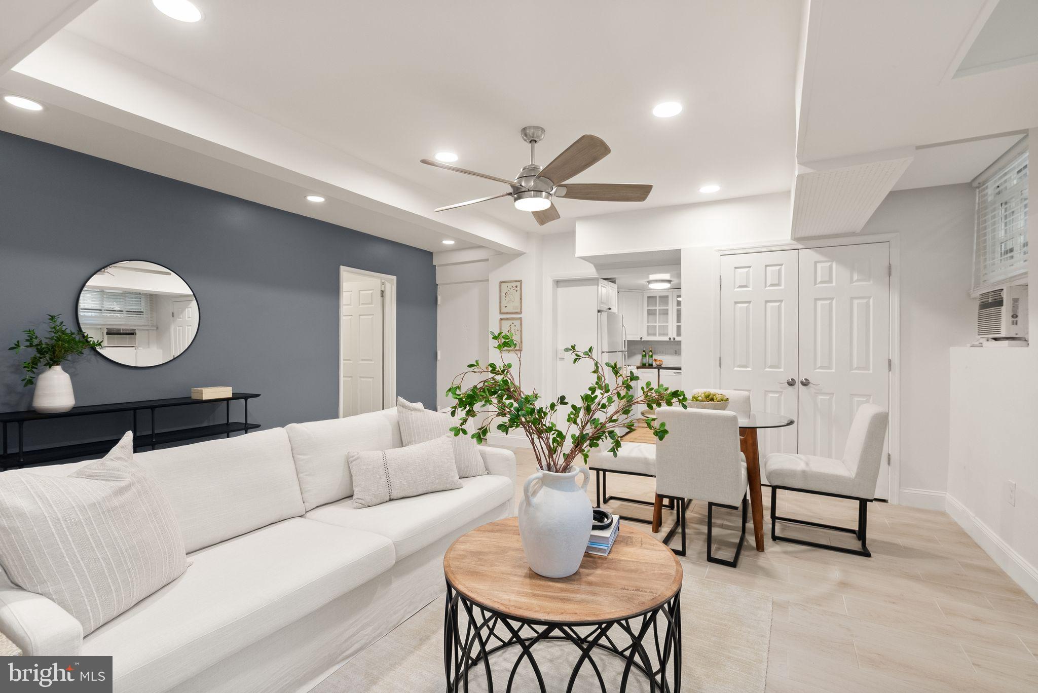 a living room with furniture potted plant and a large mirror