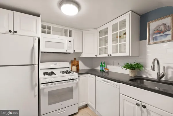 a kitchen with stainless steel appliances white cabinets and a sink