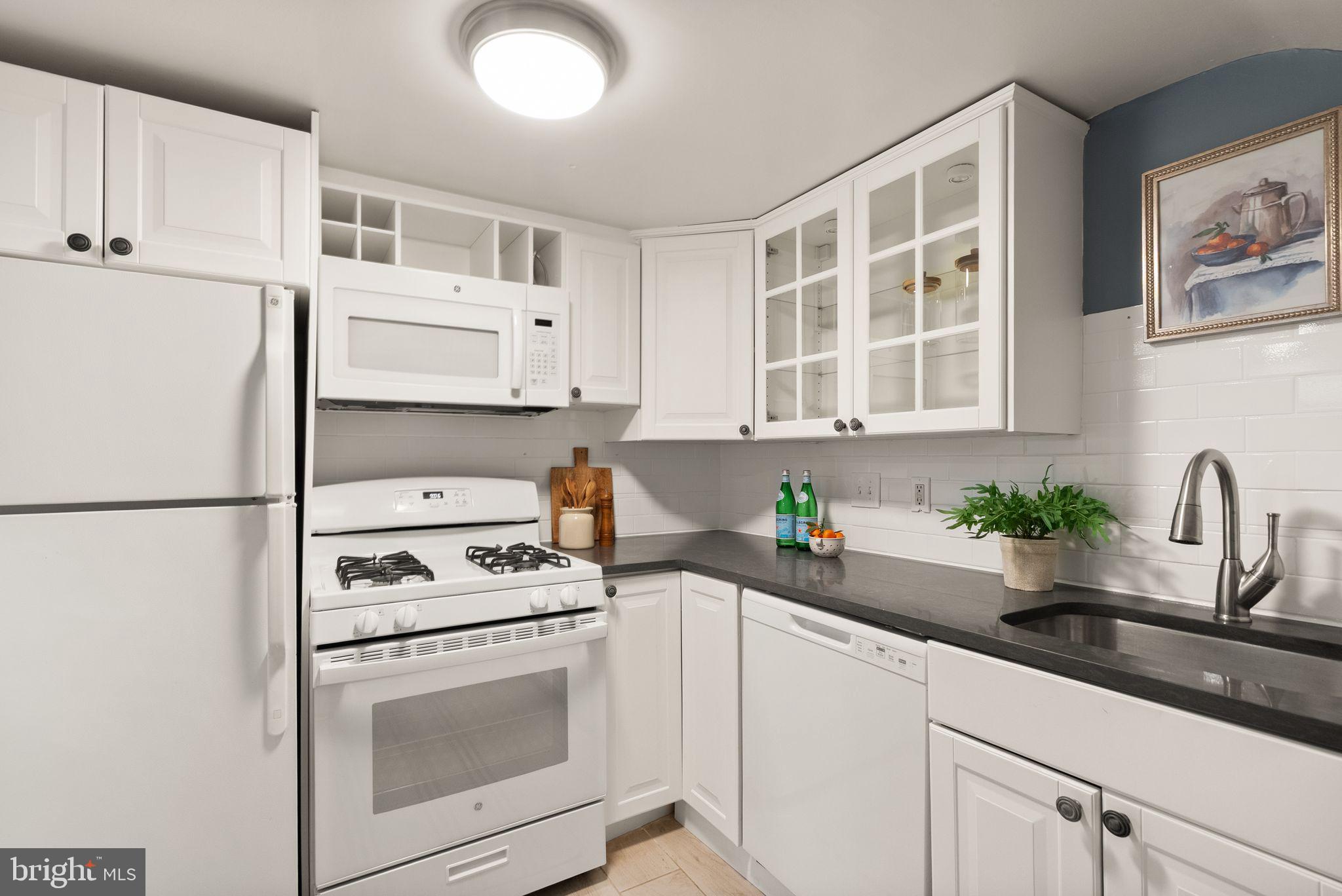 3039 Macomb Street Northwest, Unit 2A Washington, DC 20008 - Photo 9 of 30 a kitchen with stainless steel appliances white cabinets and a sink
