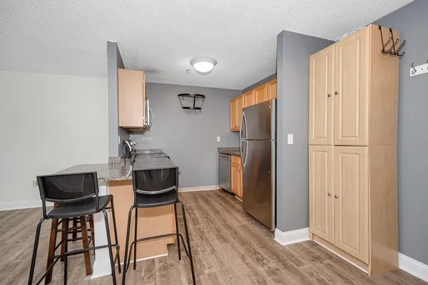a kitchen with stainless steel appliances granite countertop a refrigerator and a stove top oven