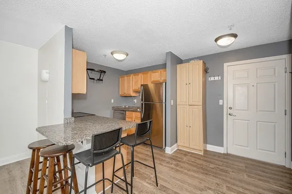 a view of a kitchen with furniture and wooden floor