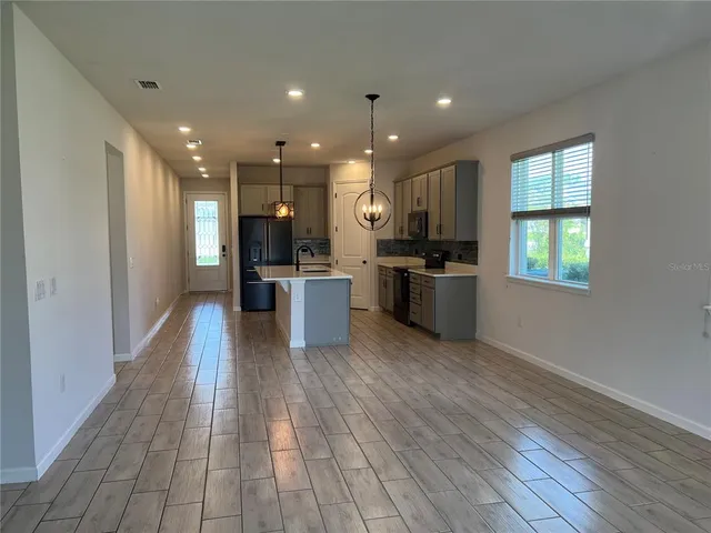 a view of kitchen with wooden floor and electronic appliances